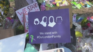 An "Our London Family" sign sits amid posters and bouquets of flowers in London, Ont. honouring the memory of four members of the Afzaal family who were killed in June 2021. (CTV News file photo)