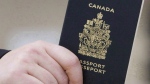 A passenger holds a Canadian passport before boarding a flight in Ottawa on Jan. 23, 2007. THE CANADIAN PRESS/Tom Hanson