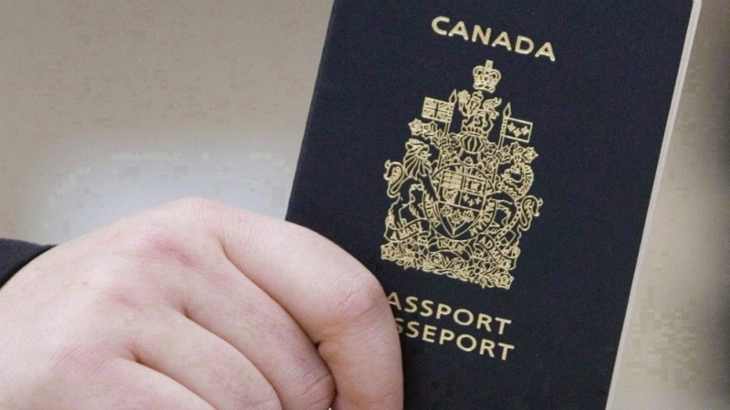 FILE - A passenger holds a Canadian passport before boarding a flight in Ottawa on Jan. 23, 2007. THE CANADIAN PRESS/Tom Hanson