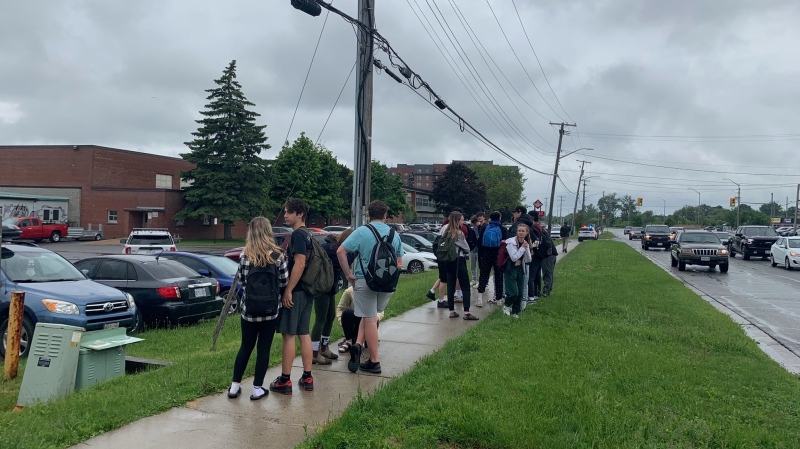 Students standing outside Frontenac Secondary School in Kingston, Ont. on Thursday after a school was placed in a lockdown. (Kimberley Johnson/CTV News Ottawa)