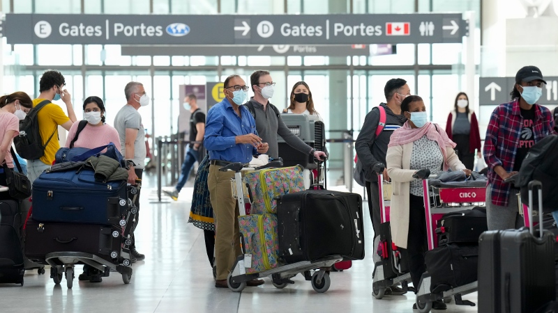 People wait in line to check in at Pearson International Airport in Toronto on Thursday, May 12, 2022. THE CANADIAN PRESS/Nathan Denette