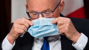 Dr. Kieran Moore, OntarioÕs chief medical officer of health places his mask on as holds a press conference regarding the lifting of most mask mandates for indoor settings in Ontario at QueenÕs Park in Toronto on Wednesday, March 9, 2022. THE CANADIAN PRESS/Nathan Denette
