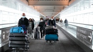 People travel at Pearson International Airport during the COVID-19 pandemic in Toronto, Friday, Dec. 3, 2021. THE CANADIAN PRESS/Nathan Denette