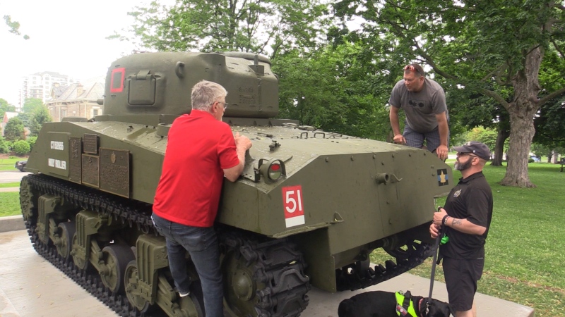 Members of the 1st Hussars examine the vandalism on the Holy Roller Tank in Victoria Park in London, Ont. on Sunday, June 12, 2022 (Brent Lale/CTV News London)