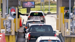 Cars line up at the Canada-U.S. border crossing on Monday, Nov. 8, 2021 (AP Photo/Elaine Thompson)