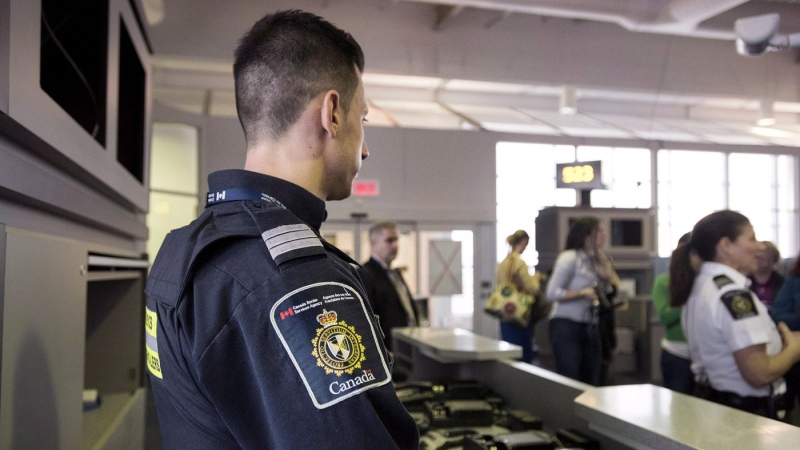 A Canadian Border Services agent stands watch at a gate on Tuesday, December 8, 2015. THE CANADIAN PRESS/Darren Calabrese