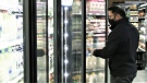 A man shops for milk in a grocery store.