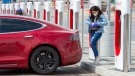 A woman prepares to plug in her Electric Vehicle in Markham, Ontario on Wednesday April 15, 2020. THE CANADIAN PRESS/Frank Gunn