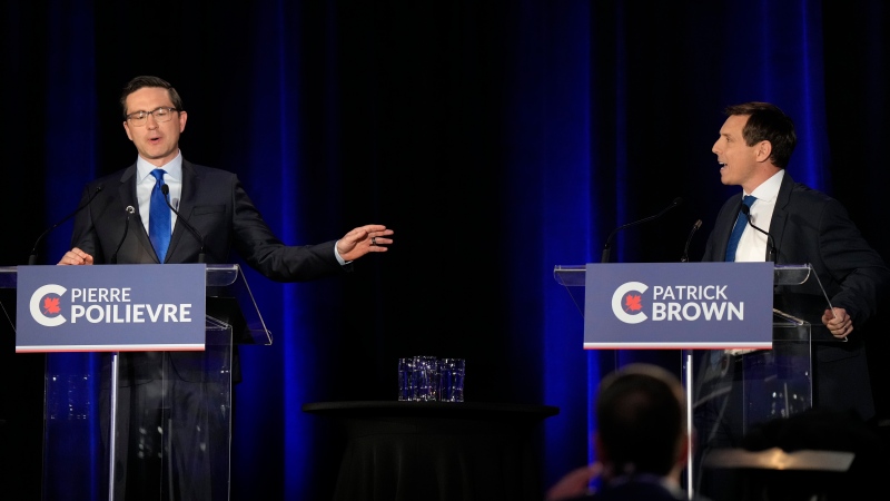 Conservative leadership hopeful Pierre Poilievre, left, and Patrick Brown share an exchange during the Conservative Party of Canada French-language leadership debate in Laval, Quebec on Wednesday, May 25, 2022. THE CANADIAN PRESS/Ryan Remiorz