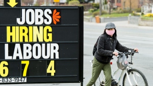 A woman checks out a jobs advertisement sign during the COVID-19 pandemic in Toronto on April 29, 2020.  (Nathan Denette / THE CANADIAN PRESS)