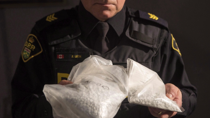 An OPP officer displays bags containing fentanyl as Ontario Provincial Police host a news conference in Vaughan, Ont., on February 23, 2017. (THE CANADIAN PRESS/Chris Young) 