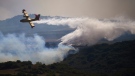 A firefighter plane drops a fire retardant on a burning area of San Martin de Unx in northern Spain, Sunday, June 19, 2022. A European heat wave has caused problems with fires in Germany and Spain. (AP Photo/Miguel Oses, File)
