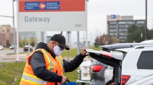 A Canada Post employee puts his bag in his trunk as he leaves the Gateway facility in Mississauga, Ontario on Wednesday April 28, 2021. THE CANADIAN PRESS/Frank Gunn