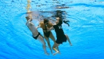 Anita Alvarez is rescued by her coach Andrea Fuentes and a unidentified person after she fainted during a solo free routine at the Swimming World Championship in Budapest, Hungary on June 22, 2022. (Getty Images)