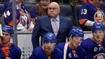 New York Islanders head coach Barry Trotz, center, looks on in the first period of an NHL hockey game against the Anaheim Ducks, Sunday, March 13, 2022, in Elmont, N.Y. (AP Photo/Adam Hunger)