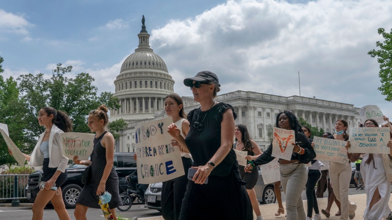 A group of abortion-rights protesters march past U.S. Capital building to join a demonstration outside the Supreme Court in Washington, Friday, June 24, 2022. (AP Photo/Gemunu Amarasinghe)