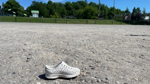 A child’s summer shoe is seen in the area of a collision where a child was struck by a bus. The incident occurred on Centennial Lane which leads to a public parking area for a playground and splash pad. (Sean Irvine/CTV News) 