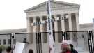 A demonstrator holding a cross protests outside of the U.S. Supreme Court, Thursday, May 5, 2022, in Washington. (AP Photo/Jose Luis Magana, File)