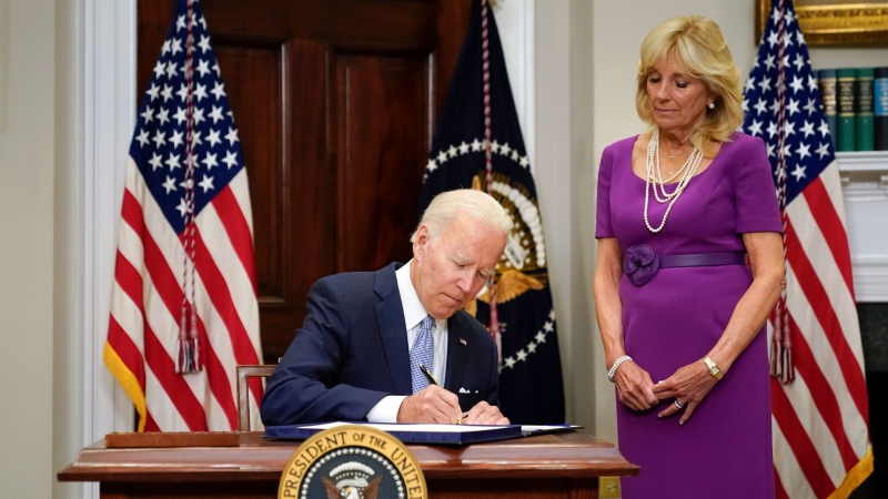U.S. President Joe Biden signs into law S. 2938, the Bipartisan Safer Communities Act gun safety bill, in the Roosevelt Room of the White House in Washington, Saturday, June 25, 2022. First lady Jill Biden looks on at right. (AP Photo/Pablo Martinez Monsivais)