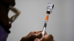 FILE - A syringe is prepared with the Pfizer COVID-19 vaccine at a vaccination clinic at the Keystone First Wellness Center in Chester, Pa., Dec. 15, 2021. (AP Photo/Matt Rourke, File)