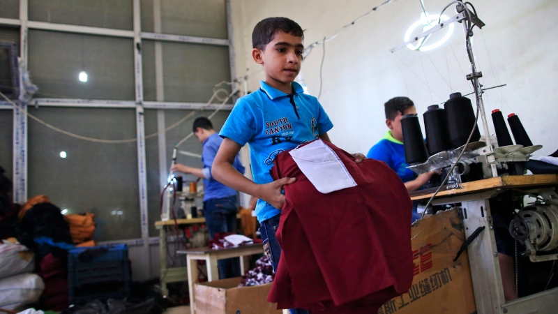 In this Thursday, June 2, 2016 photo, Ali, 10, a Syrian refugee child from Aleppo, who cannot hear and speak, works at a clothing workshop in Gaziantep, southeastern Turkey. According to the United Nation’s Children’s Fund, or UNICEF, more than half of Turkey’s 2.7 million Syrian refugees are children. (AP Photo/Lefteris Pitarakis)