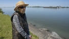 Angelique Beauchemin looks at the erosion on her property on the shore of the St. Lawrence River, in Verchères, Que., Monday, June 20, 2022. THE CANADIAN PRESS/Ryan Remiorz