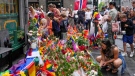 People lay flowers at the scene of a shooting in central of Oslo, Norway, Sunday, June 26, 2022. Norwegian police say they are investigating an overnight shooting in Oslo that killed two people and injured more than a dozen as a case of possible terrorism. In a news conference Saturday, police officials said the man arrested after the shooting was a Norwegian citizen of Iranian origin who was previously known to police but not for major crimes. (AP Photo/Sergei Grits)