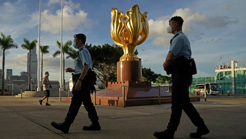 Police officers patrol at the Golden Bauhinia Square where the flag raising ceremony for the celebration of China's National Day will take place in Hong Kong, Saturday, June 25, 2022. (AP Photo/Kin Cheung)