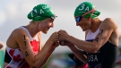 Joanna Brown of Canada, left greets Katie Zaferes of the United States before the start of the mixed relay triathlon at the 2020 Summer Olympics, Saturday, July 31, 2021, in Tokyo, Japan. (AP Photo/Francisco Seco)
