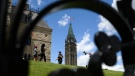 Centre Block's Peace Tower is seen behind as a Parliamentary Protective Services officer walks on Parliament Hill in Ottawa, on Friday, June 17, 2022. (Justin Tang/THE CANADIAN PRESS)