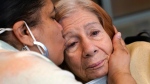 Rosa DeSoto, left, embraces her 93-year-old mother, Gloria DeSoto, who suffers from dementia, inside the Hebrew Home at Riverdale, Sunday, March 28, 2021, in the Bronx borough of New York. (AP Photo/Kathy Willens)