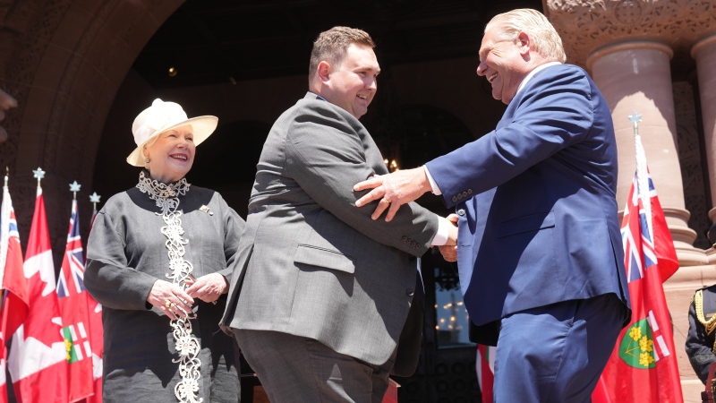 Minister of Citizenship and Multiculturalism, Michael Ford shakes hands with Premier Doug Ford as Lieutenant-Governor of Ontario Elizabeth Dowdeswell looks on, at the swearing-in ceremony at Queen’s Park in Toronto on June 24, 2022. THE CANADIAN PRESS/Nathan Denette