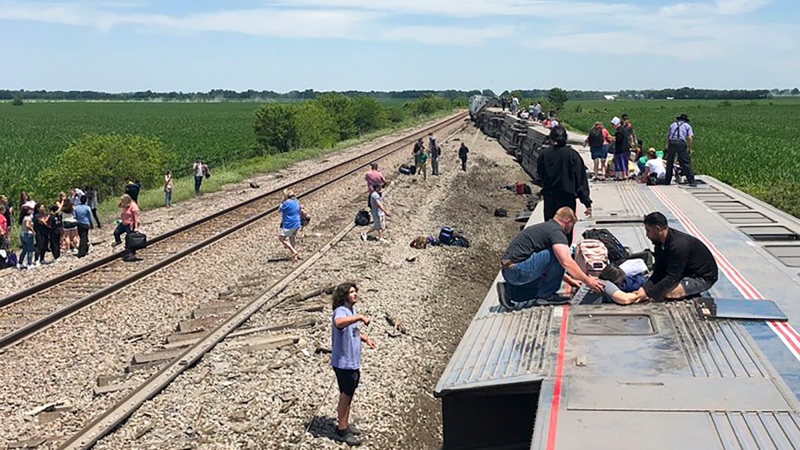 In this photo provided by Dax McDonald, an Amtrak passenger train lies on its side after derailing near Mendon, Mo., on Monday, June 27, 2022. (Dax McDonald via AP)