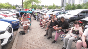People are seen lined up outside the Service Canada passport office in Surrey, B.C., on June 27, 2022. 
