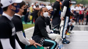 Mercedes driver Lewis Hamilton, centre, takes a knee at the starting grid before the start of the Spanish Formula One Grand Prix , on May 9, 2021. (Emilio Morenatti / AP) 