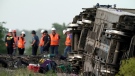 Workers inspect the scene of an Amtrak train which derailed after striking a dump truck near Mendon, Mo., on June 27, 2022. (Charlie Riedel / AP)