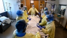 FILE - Health-care staff get ready to prone a 47-year-old woman who has COVID-19 and is intubated on a ventilator in the intensive care unit at the Humber River Hospital during the COVID-19 pandemic in Toronto on Tuesday, April 13, 2021. (THE CANADIAN PRESS/Nathan Denette)