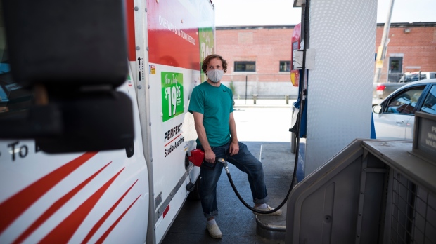 Colin Cote fills up a u-haul truck with gas at a Esso gas station in Toronto on Tuesday, June 15, 2021. THE CANADIAN PRESS/ Tijana Martin