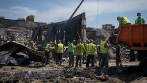 Workers clear debris at a shopping centre that was damaged in a Russian rocket attack in Kremenchuk, Ukraine, Wednesday, June 29, 2022. (AP Photo/Efrem Lukatsky)