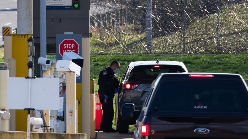 A U.S. Customs and Border Protection officer speaks to a motorist at a border crossing. THE CANADIAN PRESS/Darryl Dyck