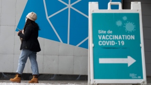 A woman leaves a COVID-19 vaccination clinic in Montreal, on Tuesday, January 4, 2022. (THE CANADIAN PRESS/Paul Chiasson)