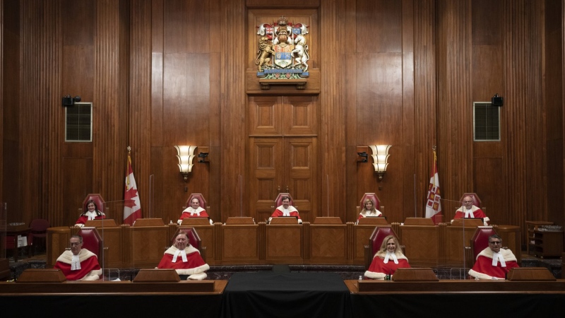 Justices of the Supreme Court pose for a photo sitting in the Supreme Court following a welcoming ceremony, Oct. 28, 2021 in Ottawa. THE CANADIAN PRESS/Adrian Wyld