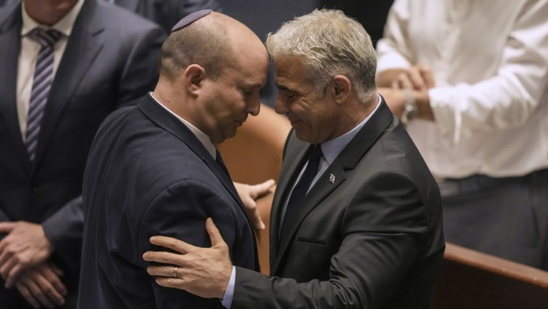 Israeli Prime Minister Naftali Bennett, left, and Foreign Minister Yair Lapid react after a vote on a bill to dissolve parliament at the Knesset, Israel's parliament, in Jerusalem, June 30, 2022. (AP Photo/Ariel Schalit)