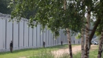 Polish border guards patrol the area of a newly built metal wall on the border between Poland and Belarus, near Kuznice, Poland, on June 30, 2022. (Michal Dyjuk) 
