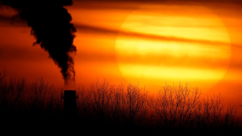 Emissions from a coal-fired power plant are silhouetted against the setting sun in Independence, Mo., on Feb. 1, 2021. (Charlie Riedel / AP) 