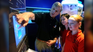 Canadian astronaut Robert Thirsk talks with students from Rockcliffe Elementary School as they get a first look at The Living In Space exhibit during its unveiling at the Canadian Aviation and Space Museum in Ottawa on Thursday, May 12, 2011. The experience may be out-of-this-world but research indicates those who travel to outer space suffer from increased bone loss. (THE CANADIAN PRESS/Sean Kilpatrick)