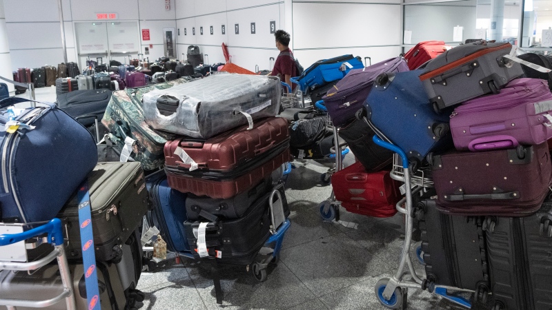 A passenger looks for his luggage among a pile of unclaimed baggage at Pierre Elliott Trudeau airport, in Montreal, Wednesday, June 29, 2022. (THE CANADIAN PRESS/Ryan Remiorz)