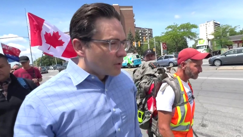 Pierre Poilievre marches in an anti-mandate protest. 