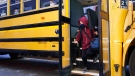 A student walks off the bus at the Bancroft Elementary School in Montreal, on Monday, August 31, 2020. (THE CANADIAN PRESS/Paul Chiasson)