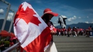 Summer Shen waves a Canadian flag while sporting a patriotic outfit during Canada Day celebrations in Vancouver, on July 1, 2019. (THE CANADIAN PRESS/Darryl Dyck)